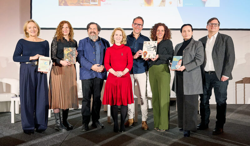 AutorInnen bei Preisverleihung mit Büchern auf Bühne